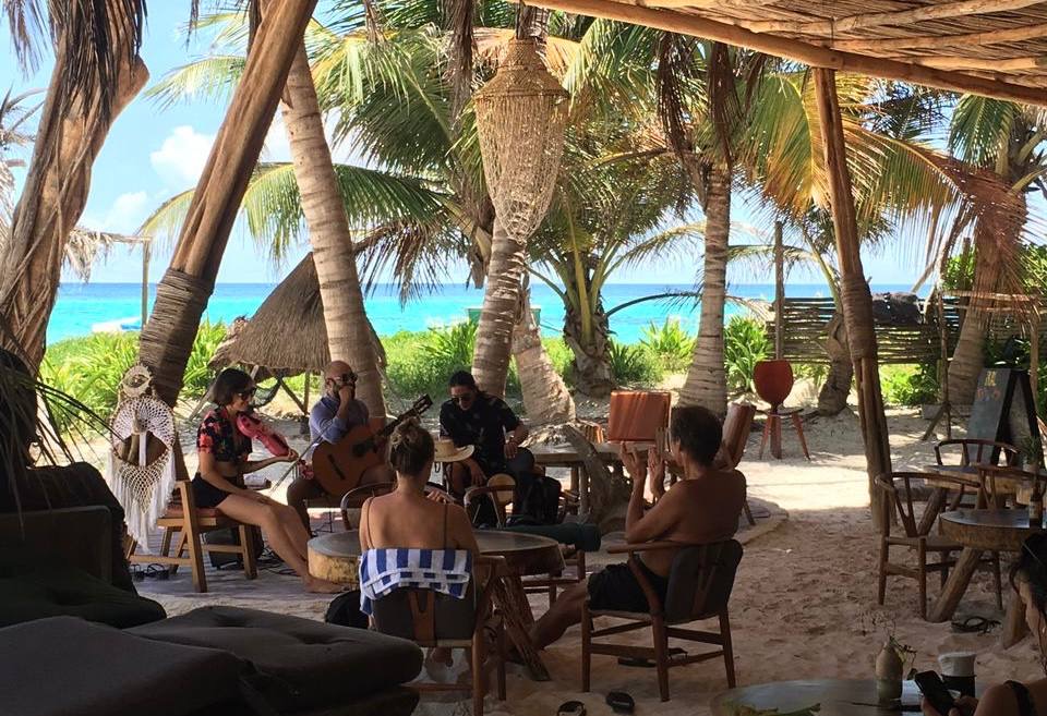 Team gathered for live music on the beach during an offsite